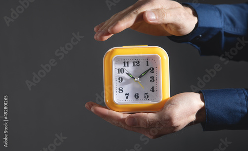 Man holding yellow clock. Business. Time management