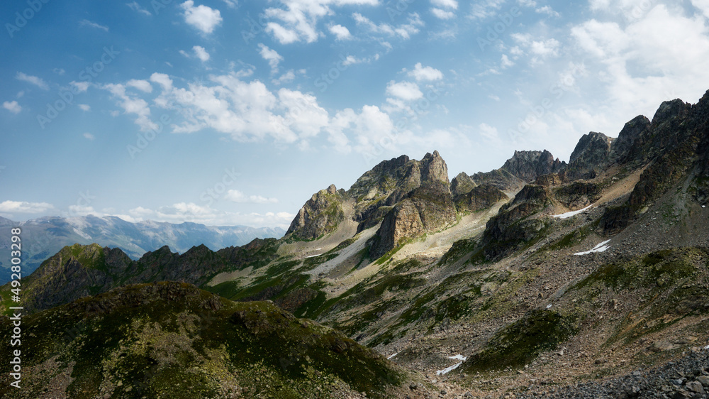 Panoramic view of turquoise Lake with surrounding sharp peaks mountains in the valley during sunny summer day. Arkhyz Panoramic view of turquoise Lake with surrounding sharp peaks mountains in the valley during sunny summer day. Arkhyz