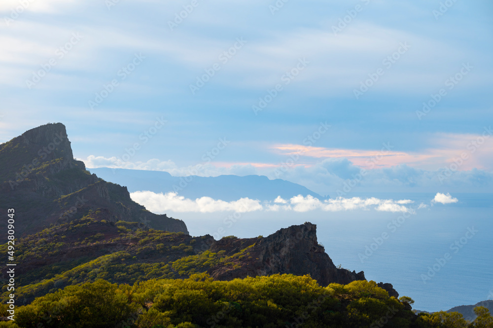 Mountains range in Rural de Teno park near isolated village Masca on Tenerife and La Gomera island on background, Canary islands, Spain Mountains range in Rural de Teno park near isolated village Masca on Tenerife and La Gomera island on background, Canary islands, Spain