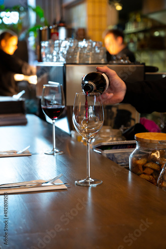 Pouring of dry Spanish tempranillo red wine in glass in Spanish bogeda restaurant