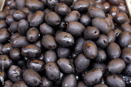 Black olives close up on market  food background