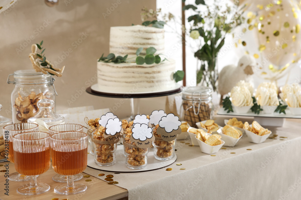 Beautiful cake and other treats on table in room. Baby shower party Beautiful cake and other treats on table in room. Baby shower party