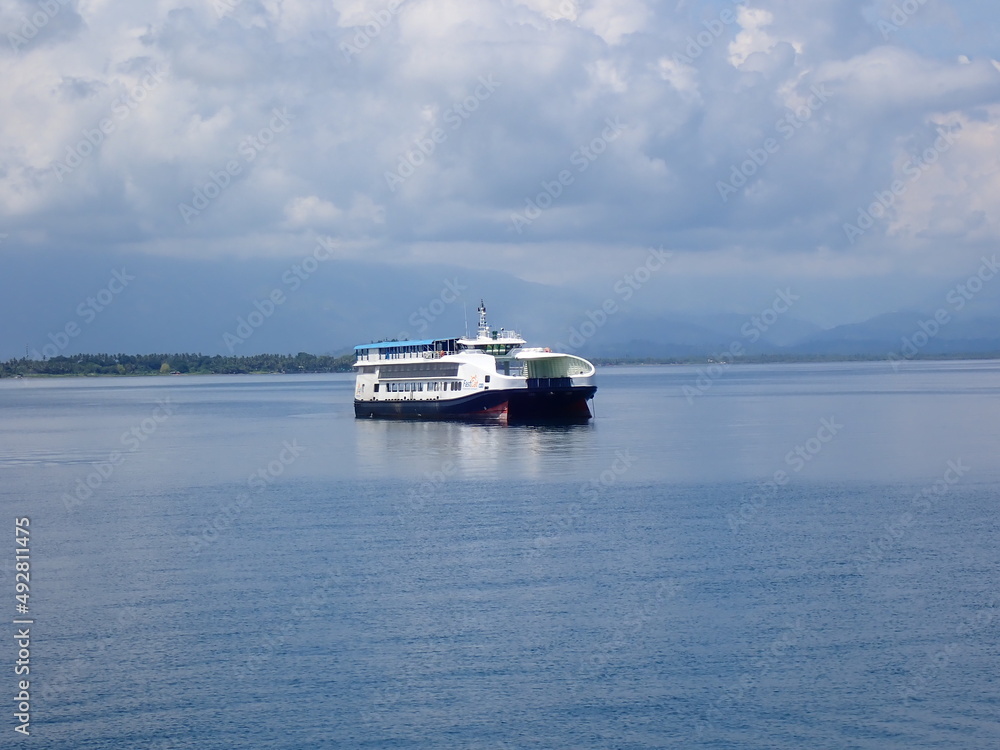 Passenger-and-freight ferry in a calm blue sea without waves. Passenger-and-freight ferry in a calm blue sea without waves.