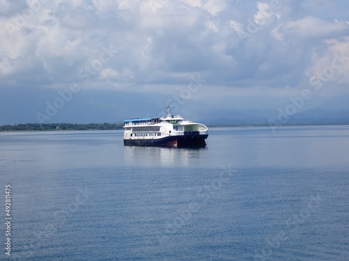 Passenger-and-freight ferry in a calm blue sea without waves. © Houston