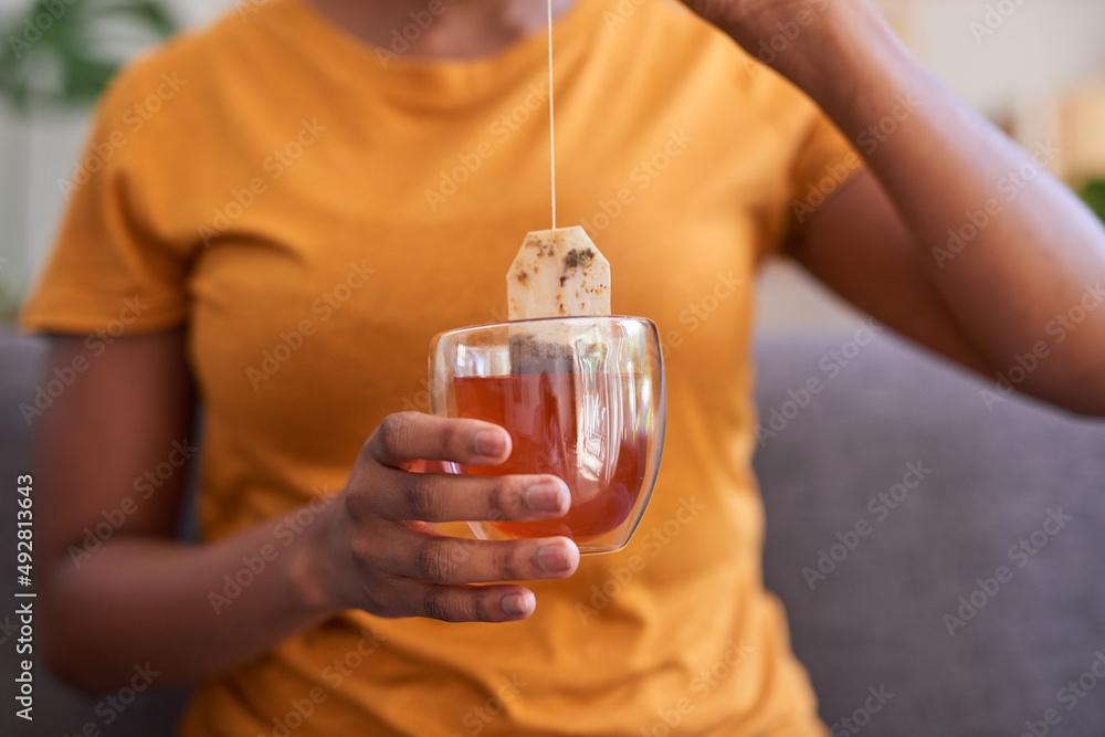 A young woman makes a cup of rooibos or red bush tea for health and wellness A young woman makes a cup of rooibos or red bush tea for health and wellness