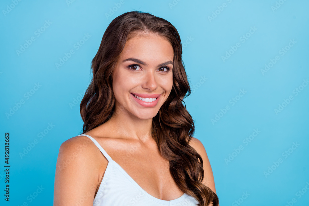 Photo of lovely brunette curly hairdo lady wear teal singlet isolated on blue color background