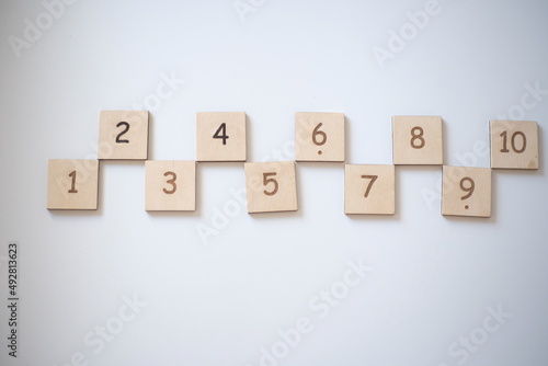Wooden bricks with numbers on very white background. Educational toys. Top view image with space for text.