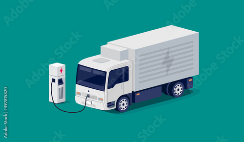 Isometric white electric city box straight truck charging parking at the charger station with a plug in cable. Vector illustration of light refrigeration utility vehicle. Electrified transport future.