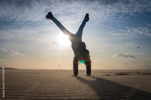 Girl doing a cartwheel on a beach