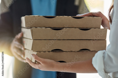 Baked fresh, delivered fast. Cropped shot of a man making a pizza delivery to a customer. photo