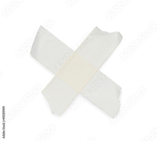 Crossed pieces of masking adhesive tape on white background, top view