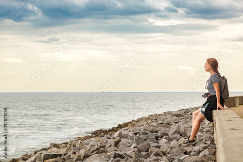 Beautiful girl on the sea with blue sky and clouds