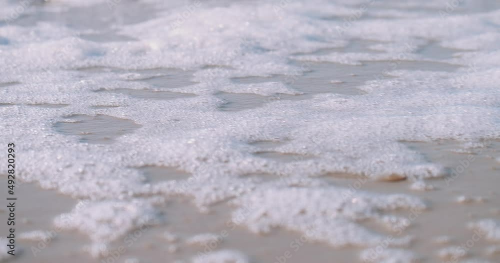 Sea Foam Washed Ashore In The Beach On A Sunny Summer Day. - close up Sea Foam Washed Ashore In The Beach On A Sunny Summer Day. - close up