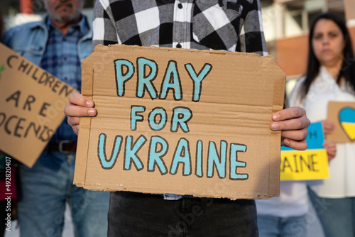 A boy demonstrator shows a cardboard sign in support of the Ukrainian people during an anti-war street protest. 