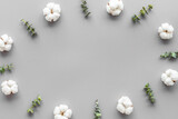 Flowers frame on gray desk with eucalyptus branches and cotton. Flat lay, top view, copy space - blog mockup