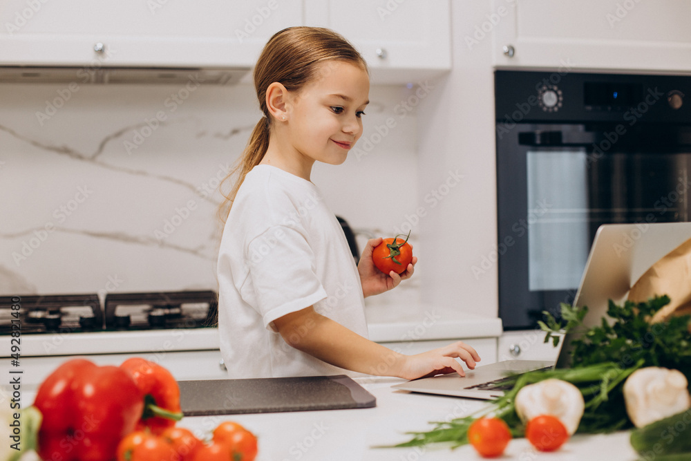 Little girl preparing salad at home at kitchen Little girl preparing salad at home at kitchen