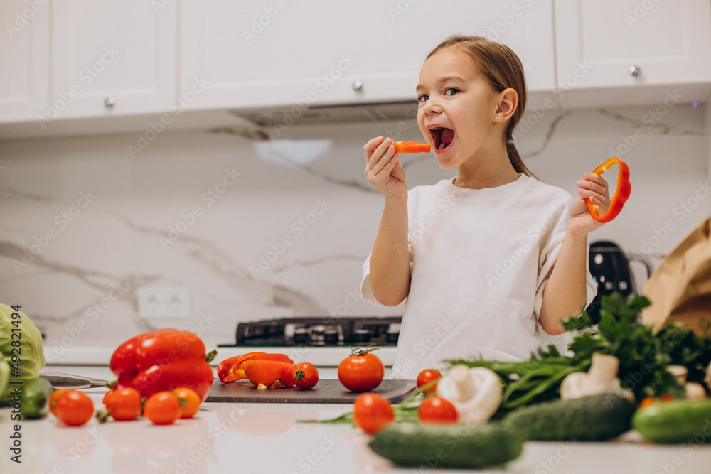 Little girl preparing salad at home at kitchen Little girl preparing salad at home at kitchen