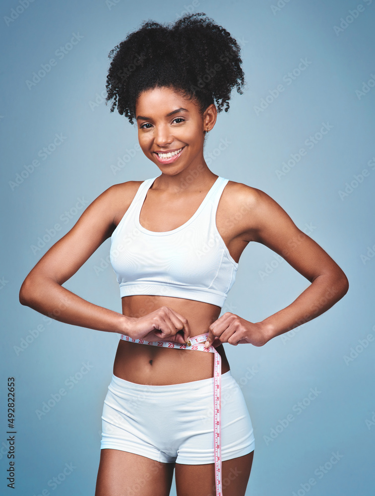 Im losing more than Ive bargained for. Shot of an attractive young woman measuring her waist against a grey background. Im losing more than Ive bargained for. Shot of an attractive young woman measuring her waist against a grey background.