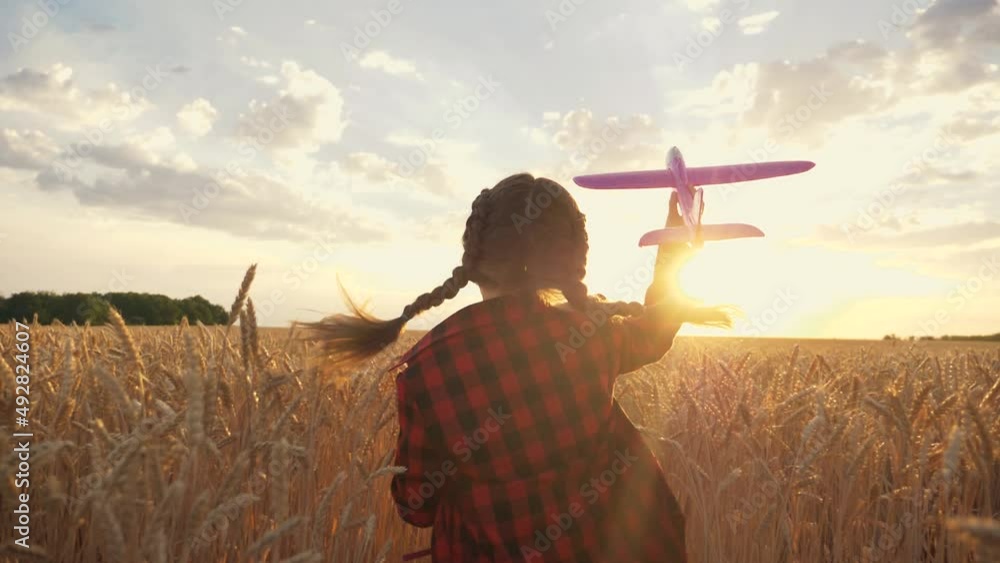 Child's flight dream. Happy child playing with toy plane in field against blue sky. baby child runs across field at sunset with toy airplane in his hand. Happy flight dream. Child's flight dream. Happy child playing with toy plane in field against blue sky. baby child runs across field at sunset with toy airplane in his hand. Happy flight dream.