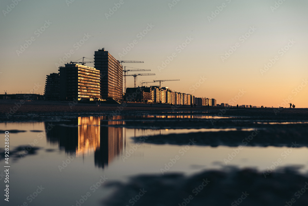 Bord de mer au coucher du soleil avec des reflets dans l'eau à Ostende en Belgique. 