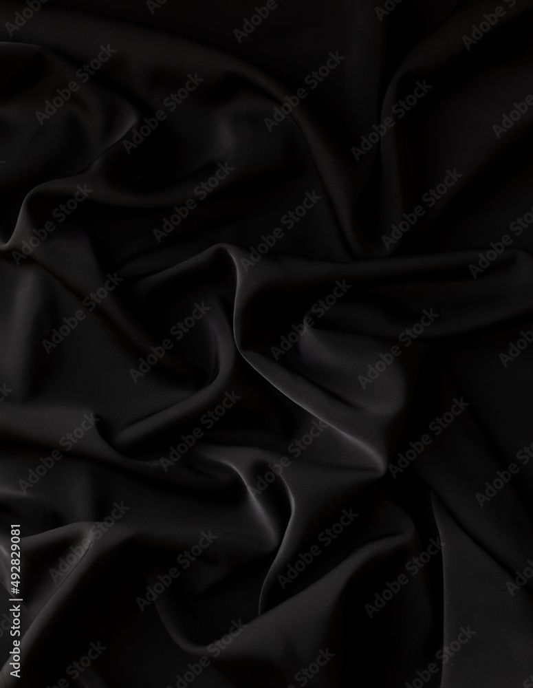 Folds of black silk background, smooth silky satin folds