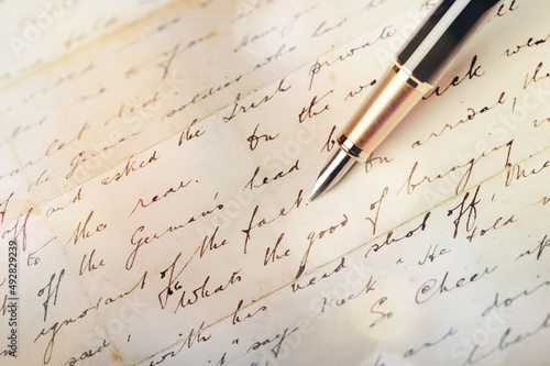 Fountain pen on an antique handwritten letter. Vintage and handwritten english cursive style photo