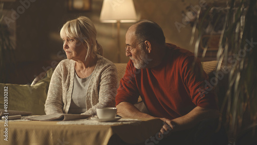 Obraz na plátně Irritated aged husband blaming upset wife while sitting on sofa at home together