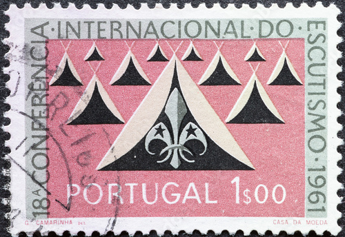Portugal - circa 1962: a postage stamp from Portugal, showing some tents and the Scout emblem Lillie. 18th International Conference of Scouting photo