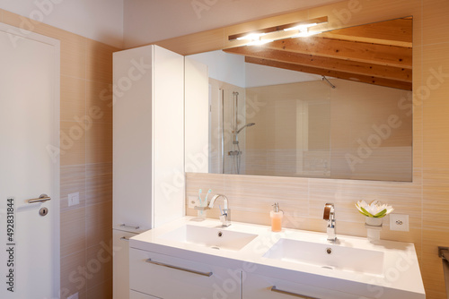 Bathroom detail with sink  mirror and toilet. exposed wooden beams