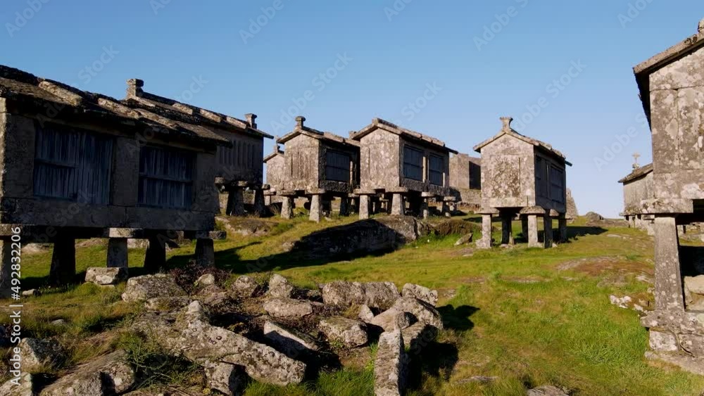 Aerial forward ascending over granaries towards Lindoso Castle, Viana do Castelo in Portugal. Sky for copy space Aerial forward ascending over granaries towards Lindoso Castle, Viana do Castelo in Portugal. Sky for copy space