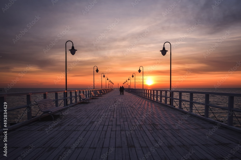 Beautiful morning seaside landscape. Wooden pier with a colorful sky in Gdynia, Poland.