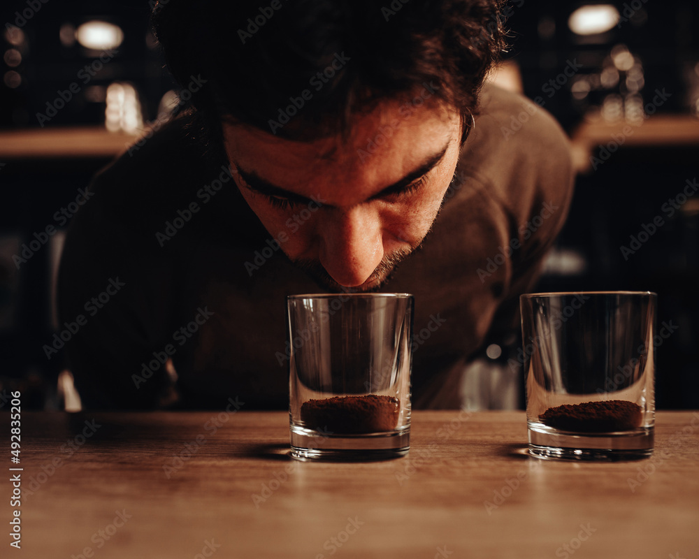 The barista chooses coffee varieties for the coffee shop by smell - he ...