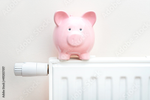 Piggy bank on radiator. Heating cost concept