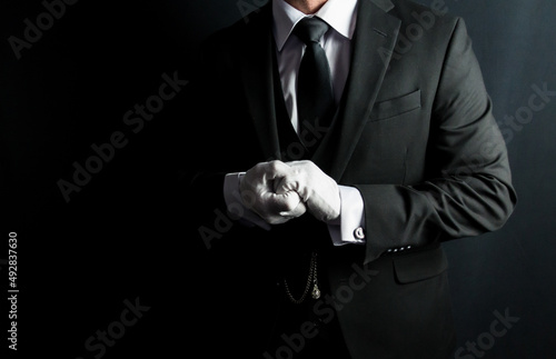 Portrait of Butler in Dark Suit and White Gloves Eager to Be of Service. Professional Hospitality and Courtesy. 