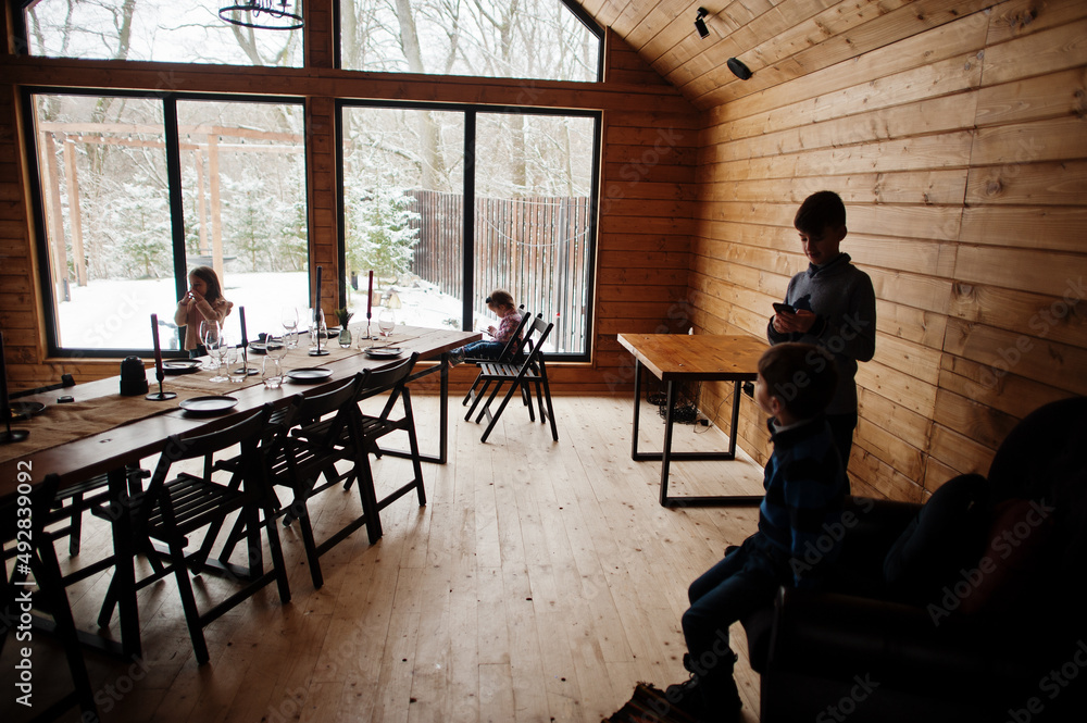 Kids play on phone in modern wooden house. Kids play on phone in modern wooden house.