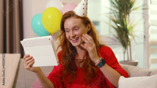 Redheaded cheerful woman celebrating birthday with best friend online videochatting sharing presents on webscreen talking at home. Remote communication. Self isolation and holidays. photo