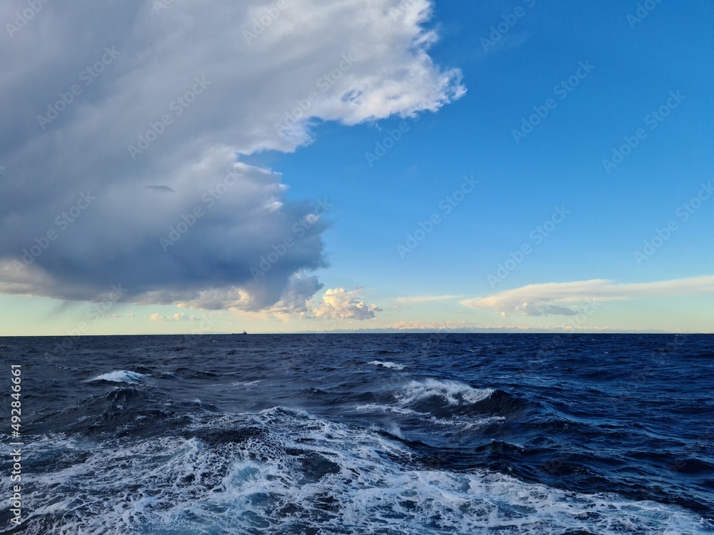 Fototapeta premium Dense gray cumulus clouds over the water surface of the sea