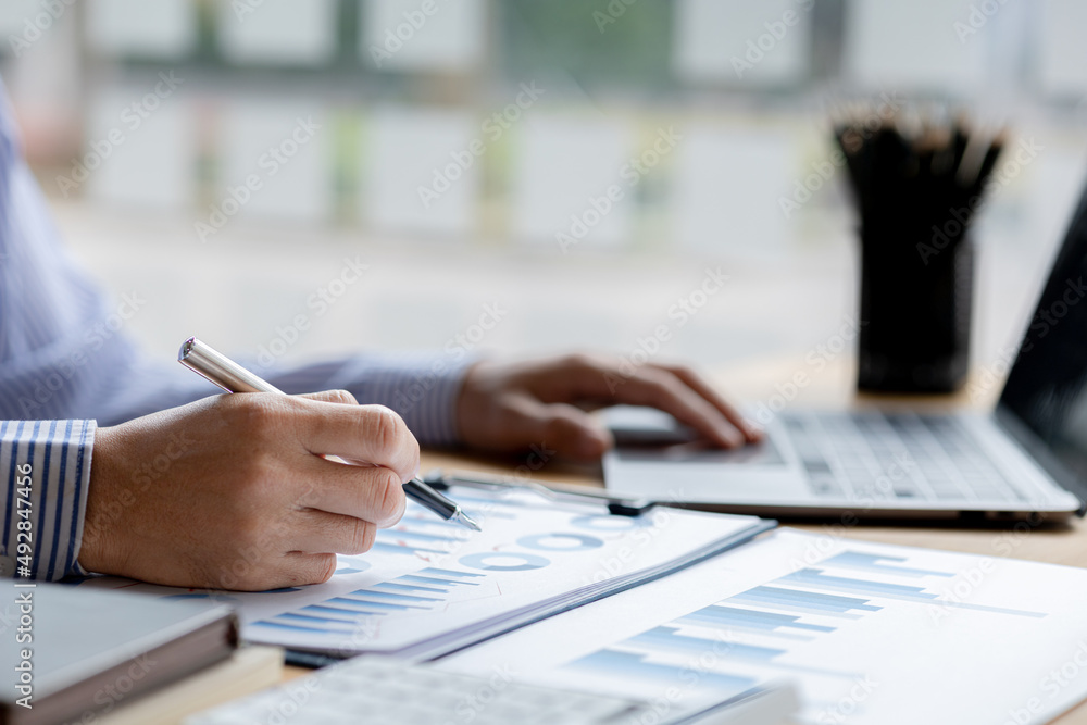 Businessman check to financial documents, he owns a startup company, he sits checking the company's financial summary prepared by the finance department. Management concept of startup company. Businessman check to financial documents, he owns a startup company, he sits checking the company's financial summary prepared by the finance department. Management concept of startup company.