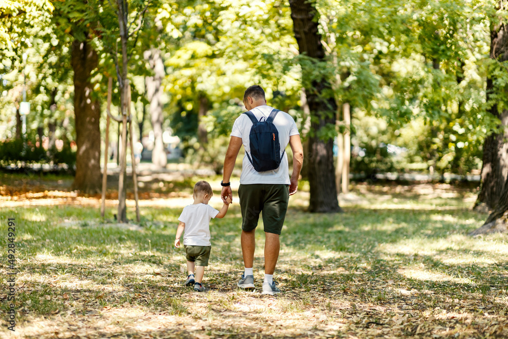 Father going for a walk with his little boy in nature on earth's day.