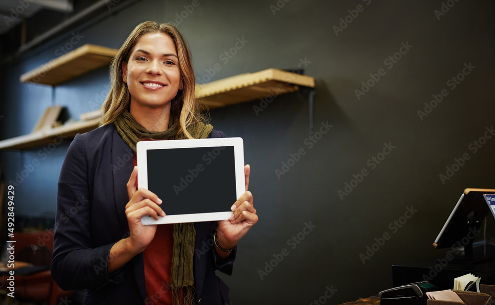 What do you think of my business website. Portrait of a young business owner using a digital tablet in her shop. What do you think of my business website. Portrait of a young business owner using a digital tablet in her shop.