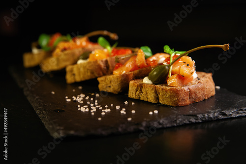 Appetizer, sandwiches with fish and herbs on plate
