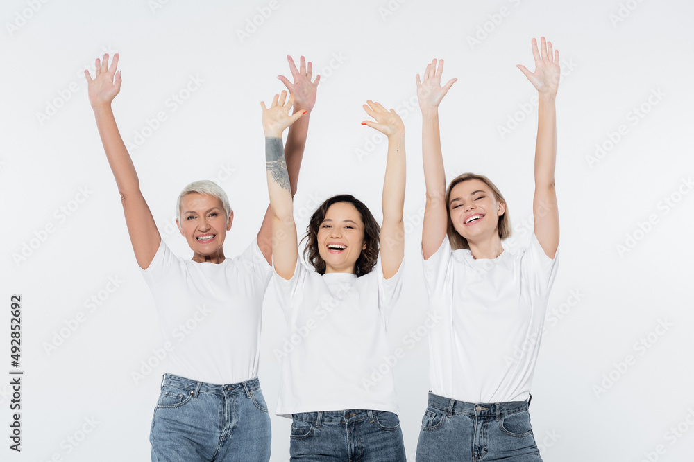 Cheerful women waving hands and looking at camera isolated on grey. Cheerful women waving hands and looking at camera isolated on grey.