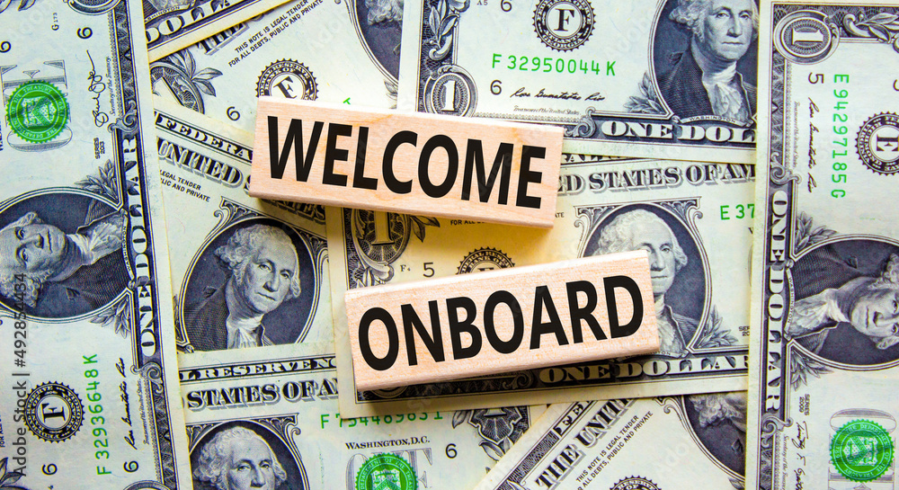 Welcome onboard symbol. Concept words Welcome onboard on wooden blocks on a beautiful background from dollar bills. Business onboarding and welcome onboard concept, copy space.