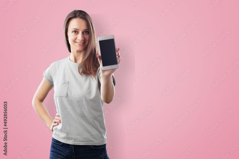 Photo of smiling woman looks with happy expression uses mobile phone for chatting online Photo of smiling woman looks with happy expression uses mobile phone for chatting online