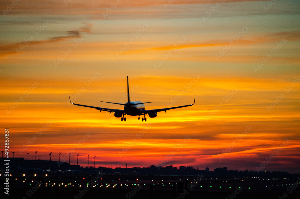 Landing of an airplane with a strong reddish sunset