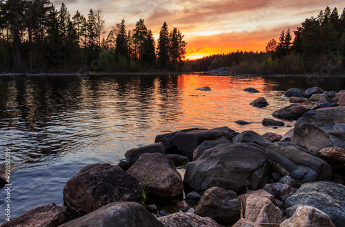 Sunset in Karelia, on Lake Ladoga, in the foreground stones in the background mountains and stones.