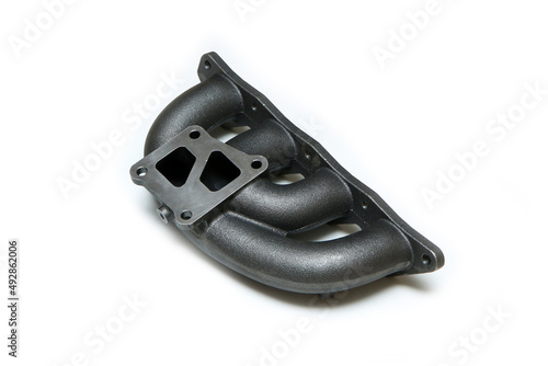The new cast iron car engine air intake manifold isolated in a white background. 