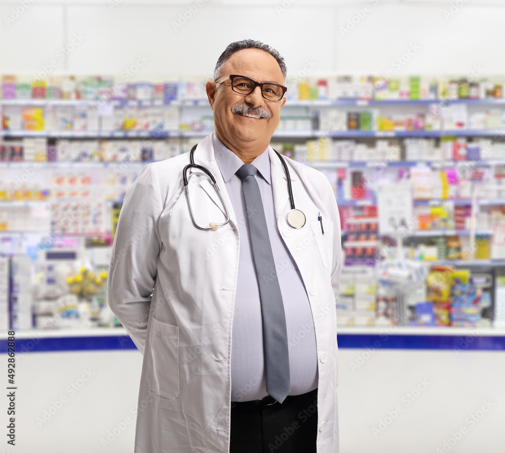 Mature male pharmacist in front of a pharmacy counter Mature male pharmacist in front of a pharmacy counter