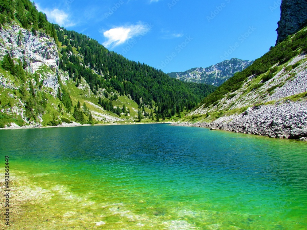 View of Krn lake on a clear sunny day with the mountain Velika Baba in Triglav national park and Julian alps in the back
