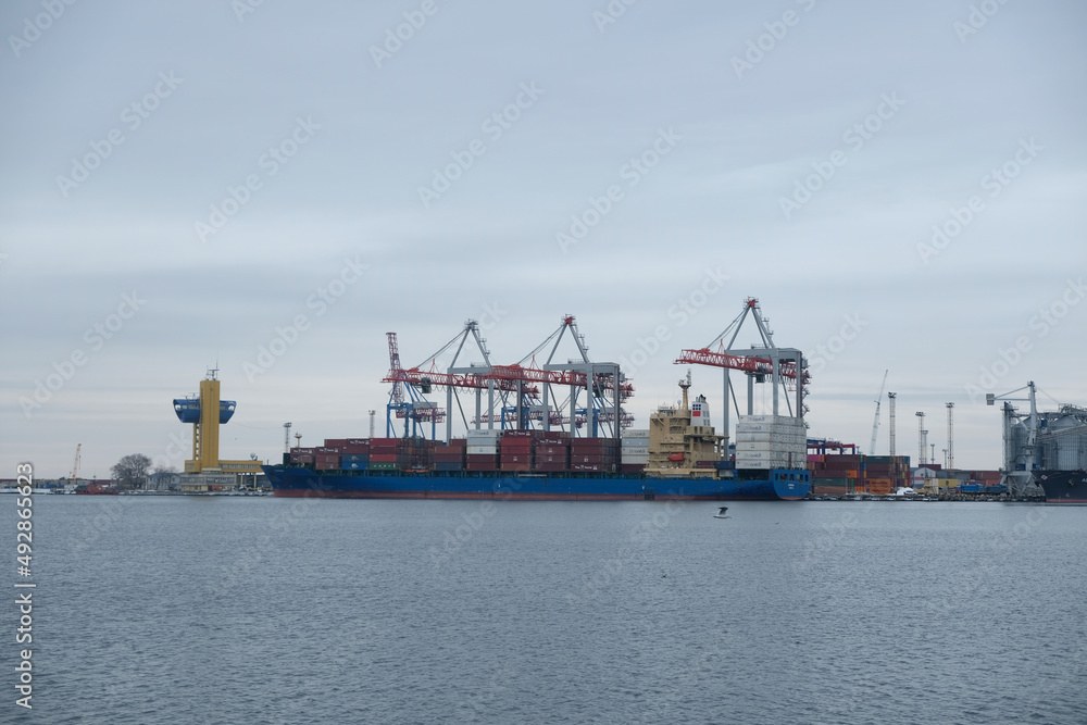 Logistics and transportation of Container Cargo ship and Cargo plane with working crane bridge in shipyard at sunrise, logistic import export and transport